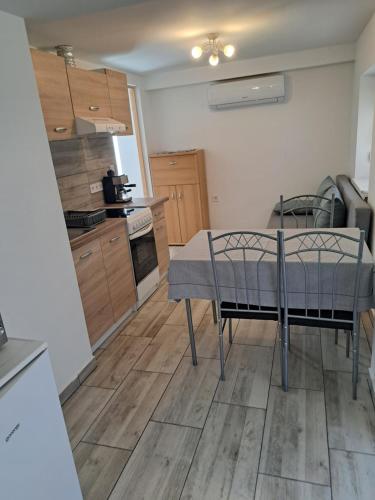 a kitchen with a table and chairs in a room at Vivien apartman in Fonyód