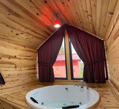 a bath tub in a wooden room with a window at Five Stars Apart in Trabzon