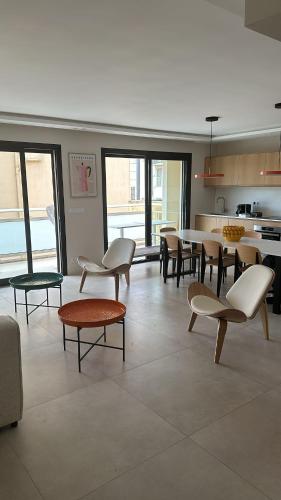 Il comprend un salon avec des tables et des chaises ainsi qu'une cuisine. dans l'établissement Ref HELV Palmes dProperties, à Cannes