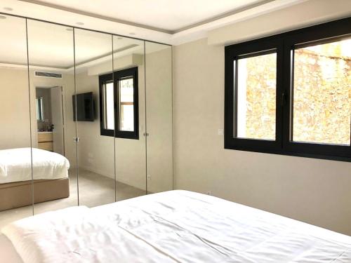 - une chambre avec un lit et un miroir mural dans l'établissement Ref HELV Palmes dProperties, à Cannes