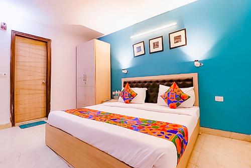 a bedroom with a large bed with a blue wall at Royal Rooms Inn Near Akhshardham Temple in New Delhi