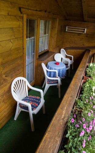 four chairs and a table on the porch of a cabin at Haus Troger in Milders