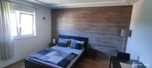 a bedroom with a bed and a wooden wall at Apartments EMMA in Kostrena
