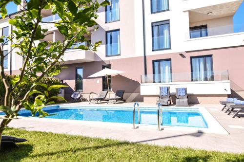 una piscina frente a un edificio en Luxury apartment Punta with sea view and swimming pool en Premantura