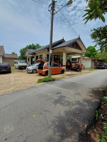 an orange car parked in front of a house at MAA HOMESTAY BATU BURUK in Kuala Terengganu