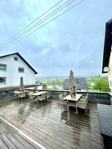 a deck with chairs and tables on top of a building at Ferienhaus Dobias in Kelberg
