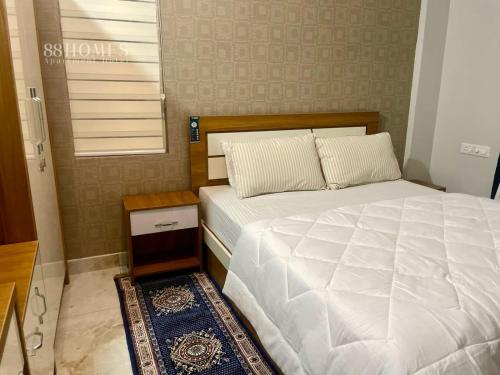 um quarto com uma grande cama branca e uma janela em Blue core em Ernakulam