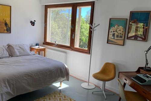 une chambre avec un lit, un bureau et une chaise dans l'établissement Magnifique Villa piscine jardin, à Fréjus