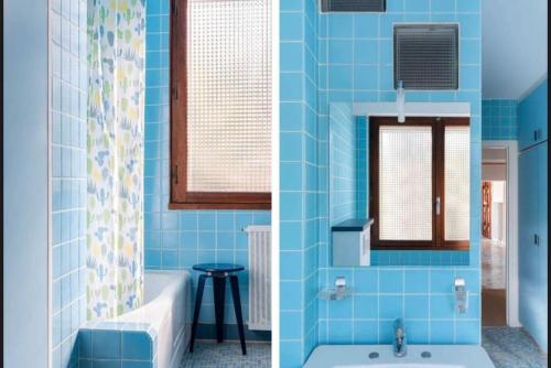 La salle de bains bleue est pourvue d'une baignoire et d'un lavabo. dans l'établissement Magnifique Villa piscine jardin, à Fréjus