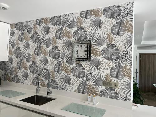 une horloge sur un mur au-dessus d'un évier dans une cuisine dans l'établissement Superbe villa golfe st Tropez, à Sainte-Maxime