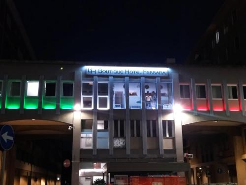 Boutique Hotel Ferrara في فيرّارا: مبنى عليه لافتة ضوء في الليل