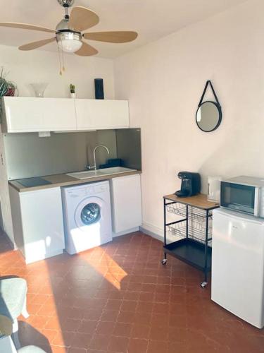 une cuisine avec un lave-linge et un micro-ondes dans l'établissement Studio Centre, 2ème ligne petite vue mer- Self Check In, à La Grande Motte