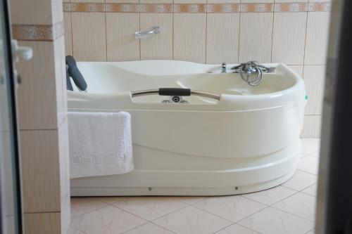 La salle de bains est pourvue d'une baignoire blanche et d'un lavabo. dans l'établissement Hotel Monte Rei, à Lushnjë
