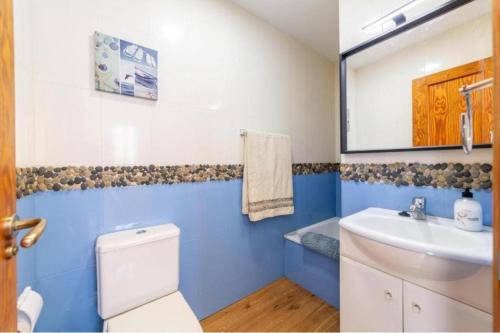 a blue and white bathroom with a toilet and a sink at Estación Las Negras in Las Negras