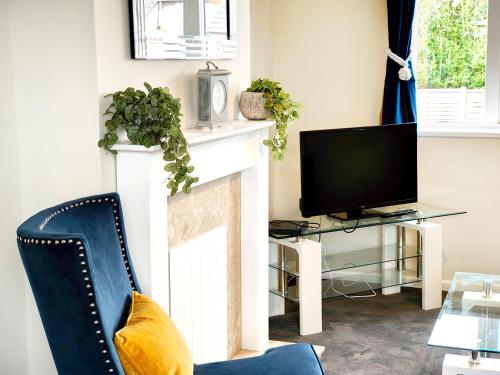 a living room with a fireplace and a tv at Terrance House, modern, spacious in Carlisle
