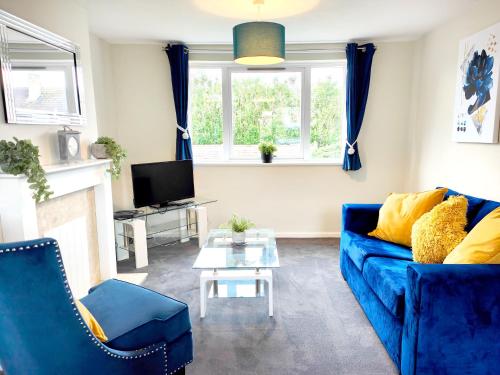 a living room with a blue couch and a tv at Terrance House, modern, spacious in Carlisle