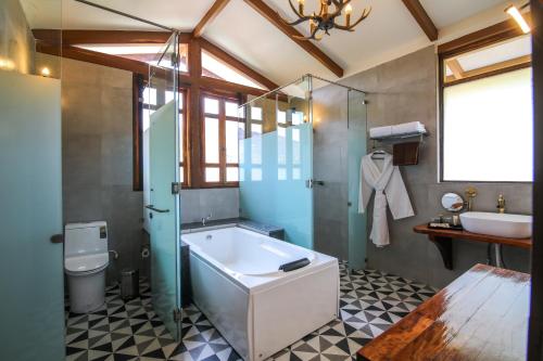 a bathroom with a tub and a toilet and a sink at Toyam by Orchid Hotels in Bhor