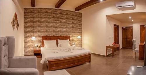 Vanya - Urban Villa and Resorts في Belparāo: غرفة نوم بسرير وجدار من الطوب