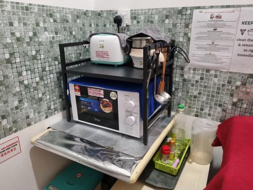 a small kitchen with a microwave on a counter at Sunway Paradise Home Staycation PH2120 SELF CHECK IN OUT in Subang Jaya