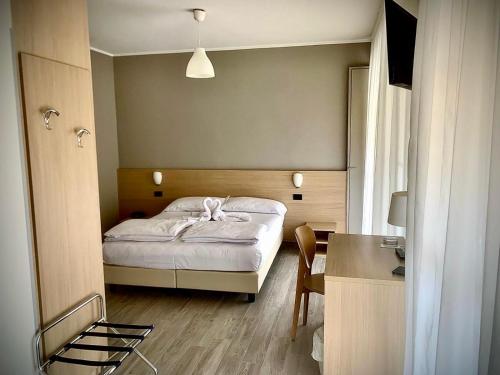 a small bedroom with a bed and a desk at Hotel Astoria in Torri del Benaco