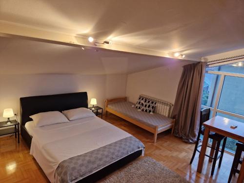 a bedroom with a bed and a bench and a window at Hestia Apartments in Rovinj