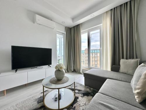 a living room with a couch and a tv at Double Studio B601 StayInn by Cosmopolis in Ştefăneştii de Jos