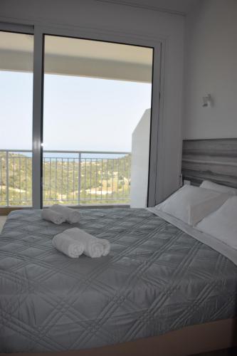 a bedroom with a large bed with towels on it at AKAMAS THRONE APARTMENTS in Neo Chorio