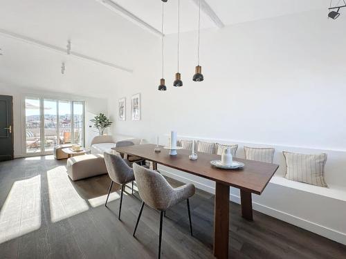 - un salon blanc avec une table et des chaises en bois dans l'établissement 79m2 Penthouse, Palais et plages à 400m rooftop, à Cannes