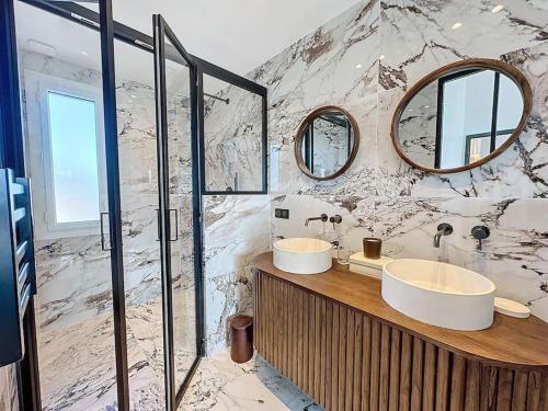 une salle de bain avec deux lavabos et deux miroirs dans l'établissement 79m2 Penthouse, Palais et plages à 400m rooftop, à Cannes