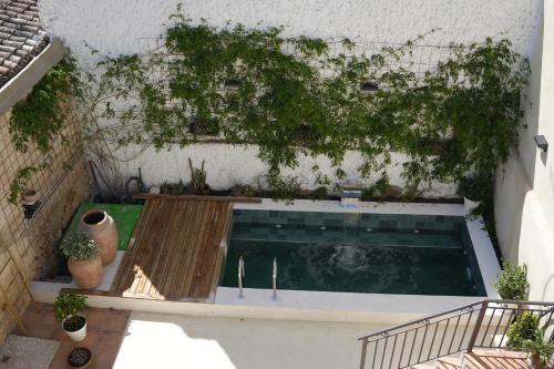 una piscina con plantas al lado de un edificio en Estancia dos Olivos, en Quesa