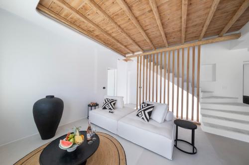 a living room with a white couch and a table at Deliades Hotel in Ornos