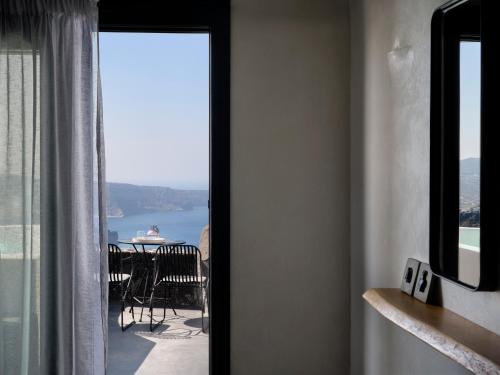a room with a view of a table and a balcony at Stella Rocca A Mare in Imerovigli