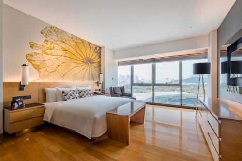 ein Schlafzimmer mit einem großen Bett mit einem großen Gemälde an der Wand in der Unterkunft Wingtech Hotel in Huangshi
