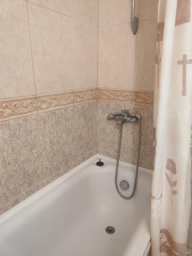 a white bath tub with a shower curtain in a bathroom at Jacky's Apartament - Апартамент в Свети Влас in Sveti Vlas