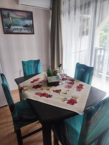 a table with a table cloth with flowers on it at Jacky's Apartament - Апартамент в Свети Влас in Sveti Vlas