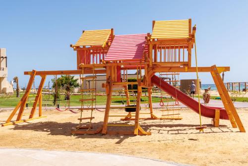 a playground with three chairs and a slide at True Beach Resort in Marsa Alam City