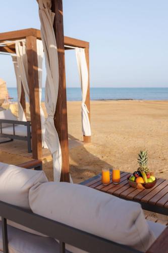 a bed and fruit on a table on the beach at True Beach Resort in Marsa Alam City
