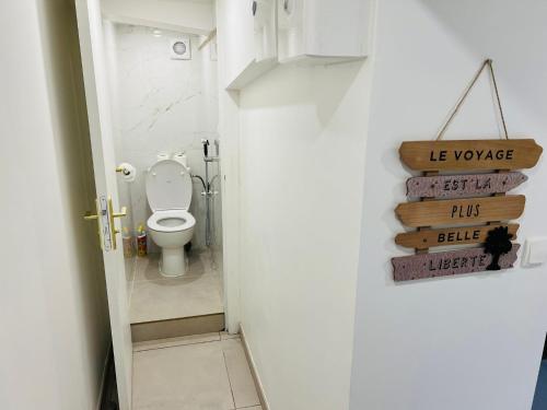 a bathroom with a toilet and a sign on the door at Appart Jardin Lac Casino Enghien Les Bains Paris JO2024 in Soisy-sous-Montmorency