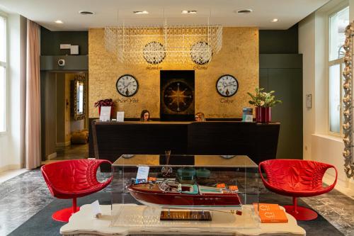 a lobby with a glass table and two red chairs at Araba Fenice Hotel in Iseo
