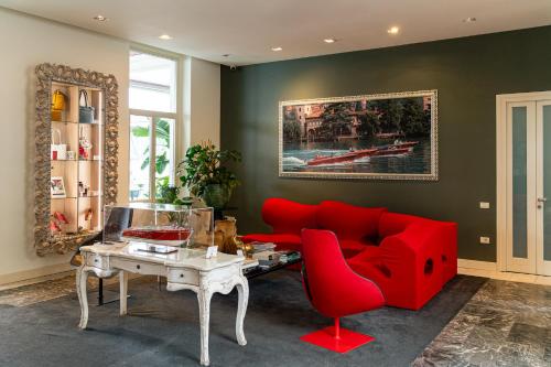 a living room with a red couch and a table at Araba Fenice Hotel in Iseo