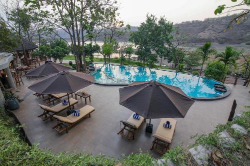 an overhead view of a pool with chairs and umbrellas at Toyam by Orchid Hotels in Bhor