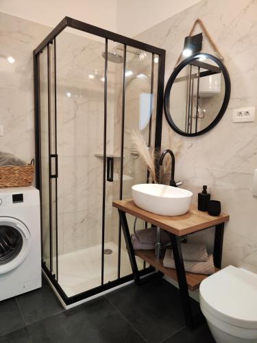 a bathroom with a sink and a washing machine at King's Apartment in Baška