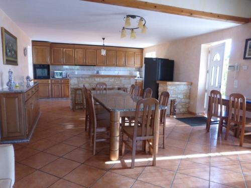Il comprend une cuisine équipée d'une table et de chaises. dans l'établissement VILLA QUERCY PERIGORD 19 PERSONNES, à Monségur