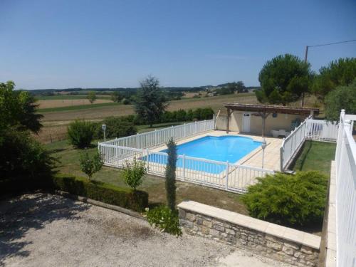 une maison avec une piscine et une clôture blanche dans l'établissement VILLA QUERCY PERIGORD 19 PERSONNES, à Monségur