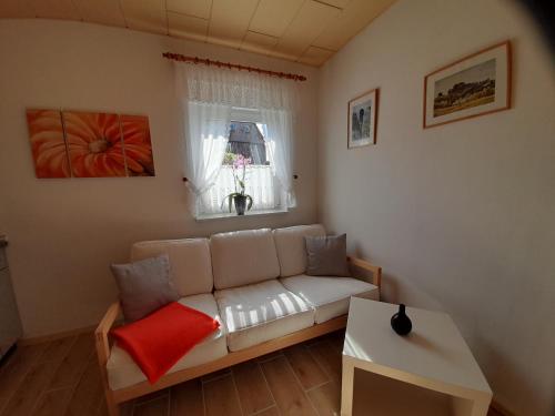 a living room with a white couch and a window at Ferienwohnung 2 Füssel in Reinhardtsdorf