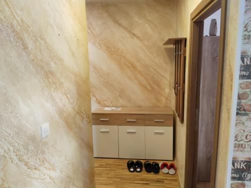 un corridoio con una fila di scarpe in una stanza di Apartment Burence a Novi Sad