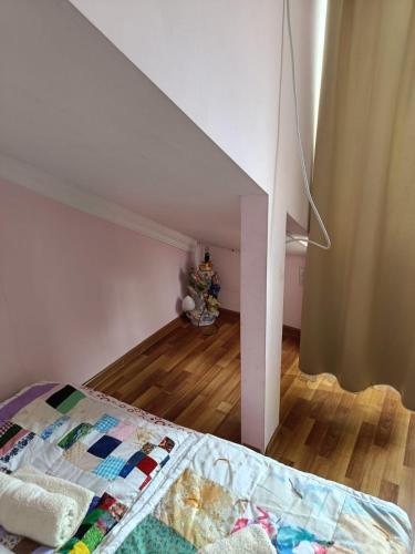 a bedroom with a bed in a room with an attic at Guest House Nise in Tbilisi City