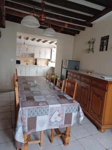 - une cuisine avec une table, des chaises et une table dans l'établissement Gite de la Bouvotte, à Neuville-sur-Vanne