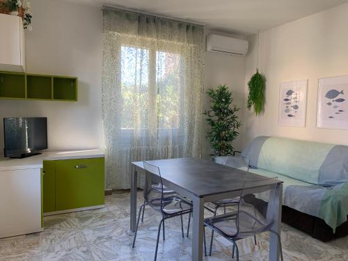 un piccolo soggiorno con tavolo e letto di Appartamento La Pineta a Marina di Cecina