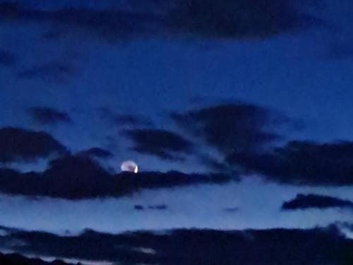 a moon in a cloudy sky at night at Trilly House in Perledo